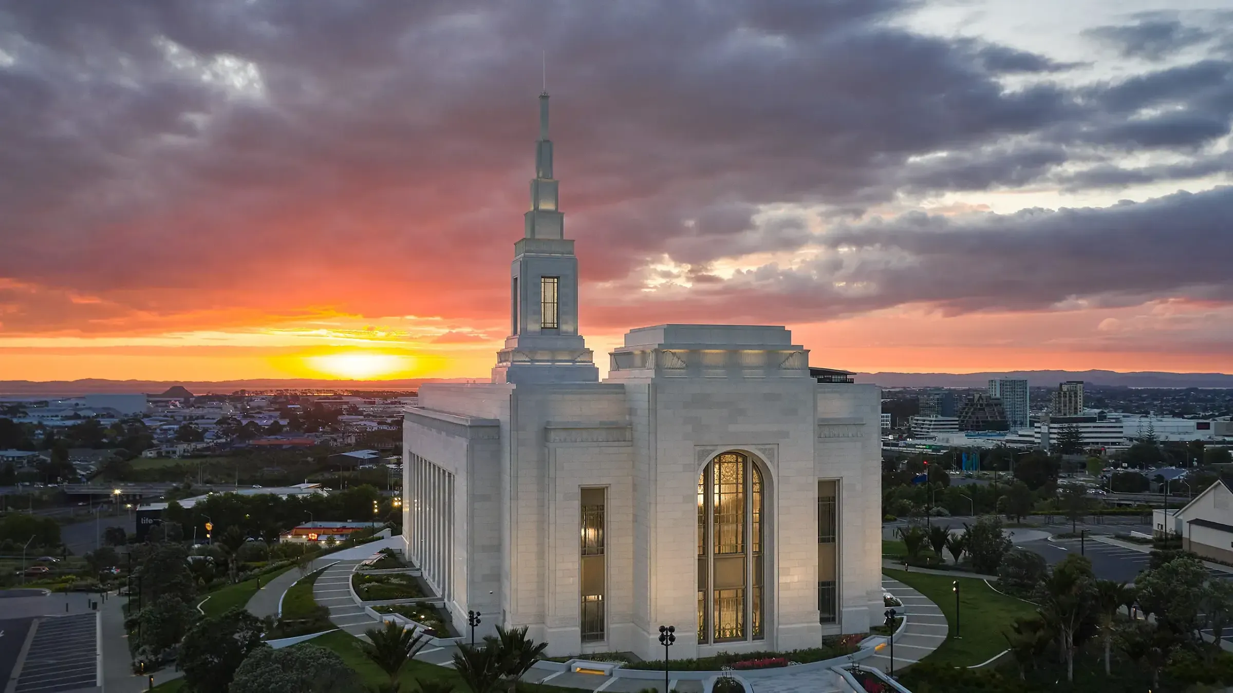 Auckland New Zealand Temple at sunset with the city behind it