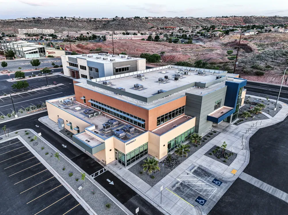 Aerial view of the two-story clinic and its parking lot with hills behind.