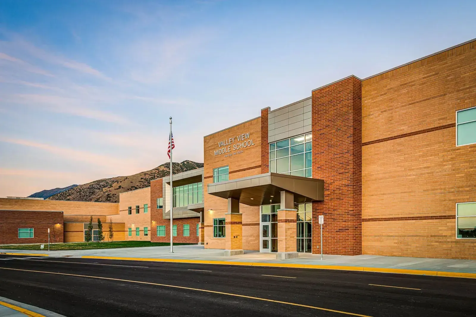 Main entrance with the Valley View Middle School sign, a covered entry, a flagpole and tan and red brick walls.