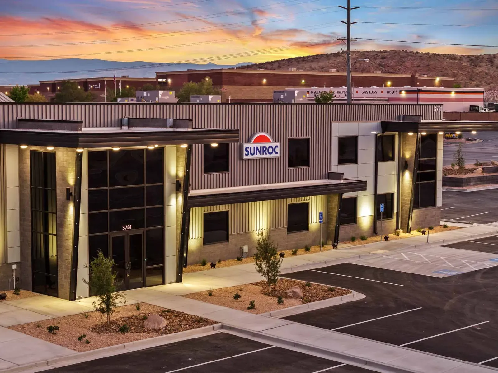 Elevated view of the office entrance at sunset with the Sunroc sign and desert hills behind.
