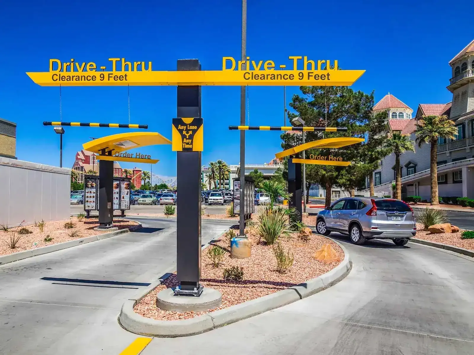 Drive-thru entrance canopy with a 9-foot clearance sign over the lanes and order stations.