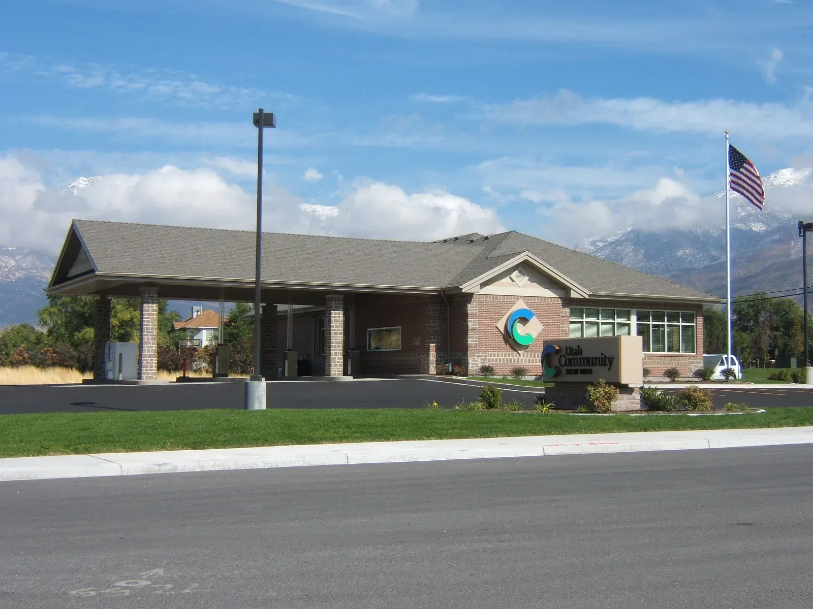 Highland branch with a drive-up canopy and brick walls in front of a mountain range.