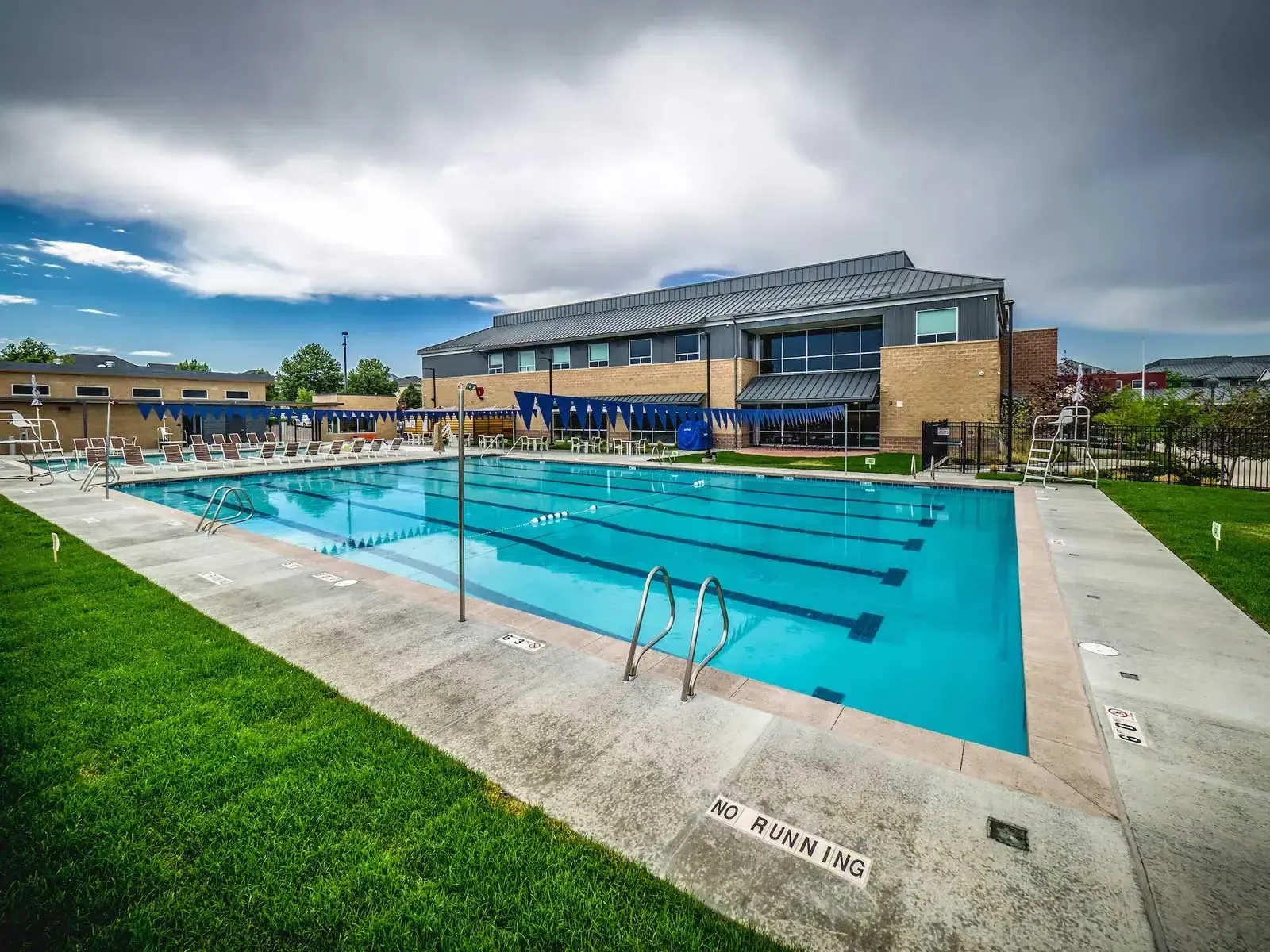 Outdoor pool with lap lanes and the recreation center building behind it.