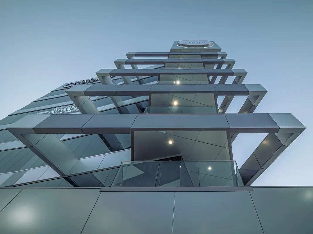 Looking up at the tower's stacked cantilevered balconies against the sky