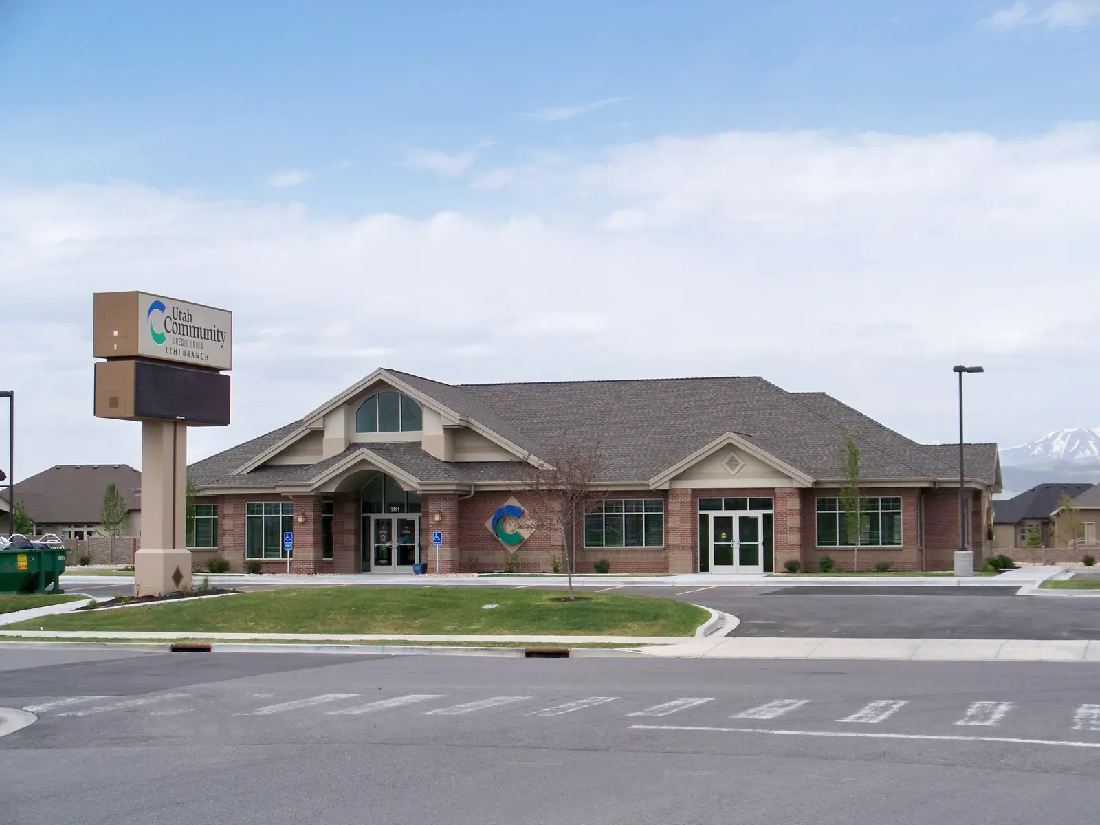 Lehi branch with a brick entry under gabled roofs and a tall roadside sign reading Utah Community Credit Union.