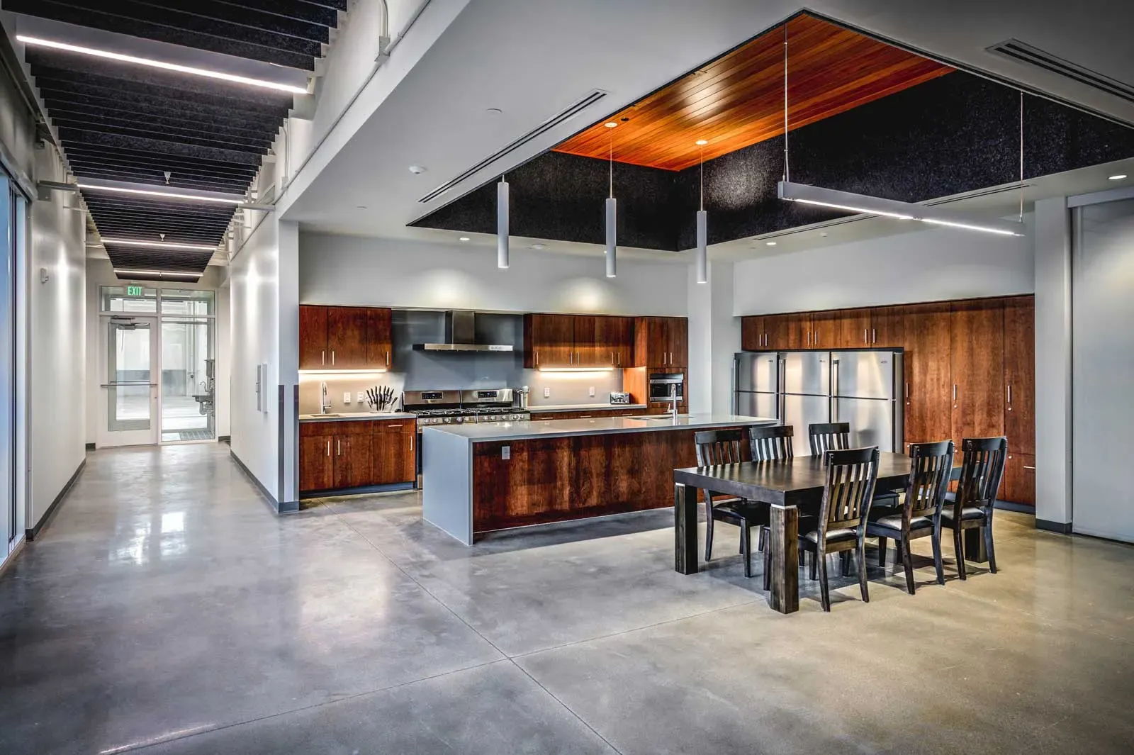 Kitchen and dining area with wood cabinets, a large island and a long dark wood table.