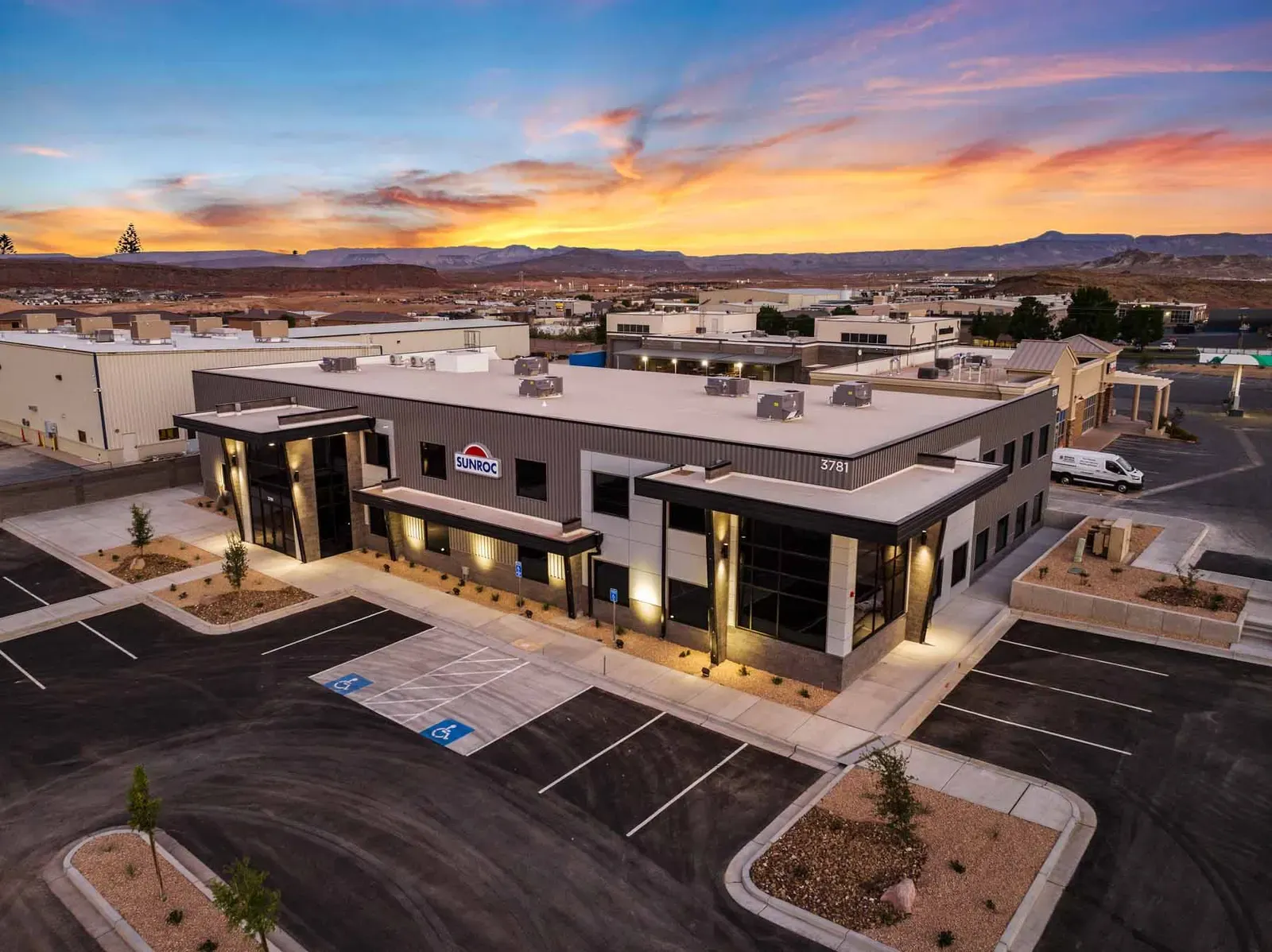 Aerial view of the two-story office building and its parking lot at sunset.