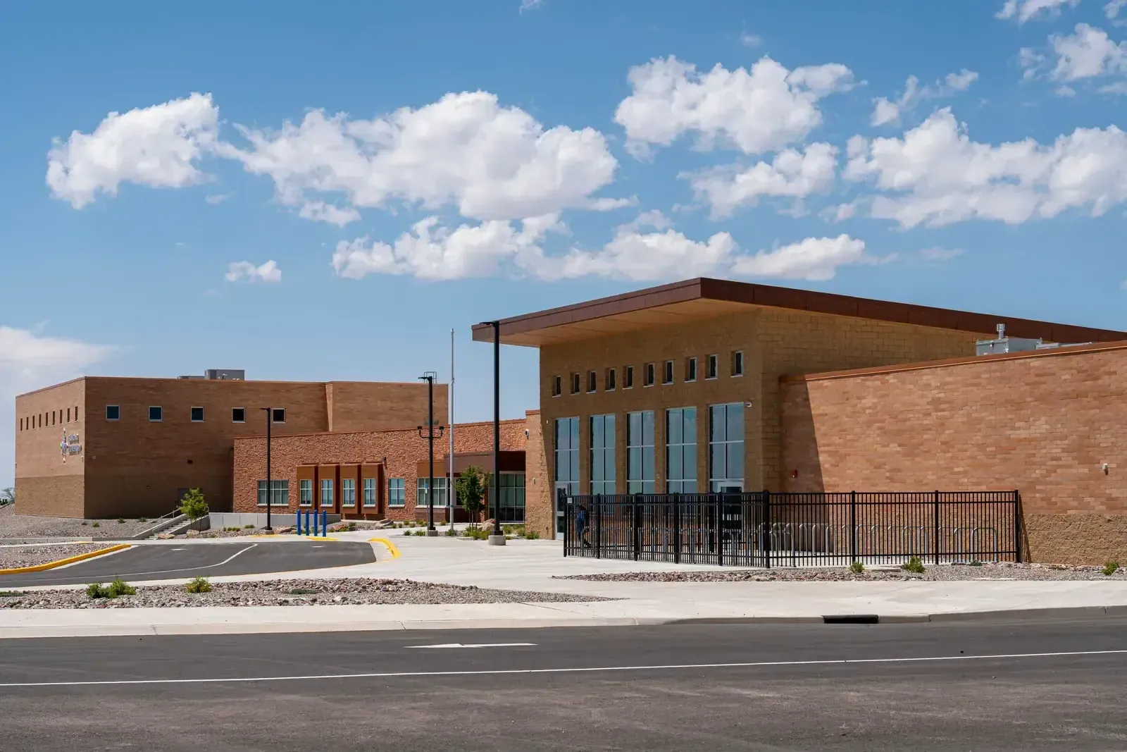 Corner of the school's brick exterior with a tall glass section under a flat canopy roof.