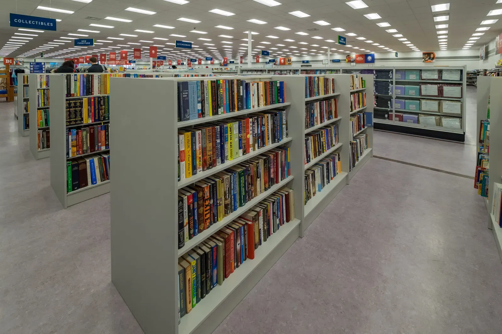 Store aisle lined with shelves of books, with a Collectibles sign overhead.
