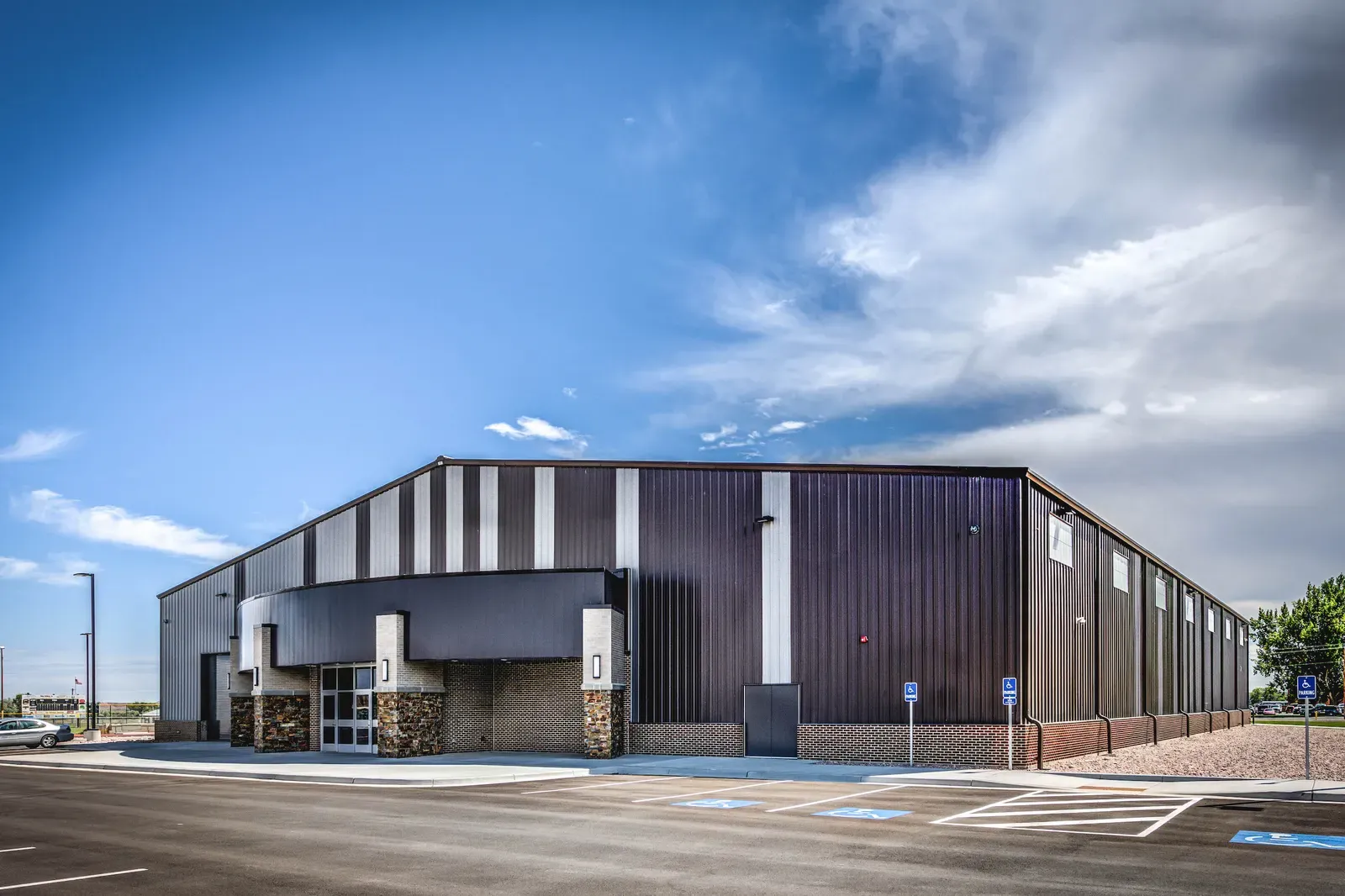 Exterior of the large metal-clad training building with a stone-clad entry