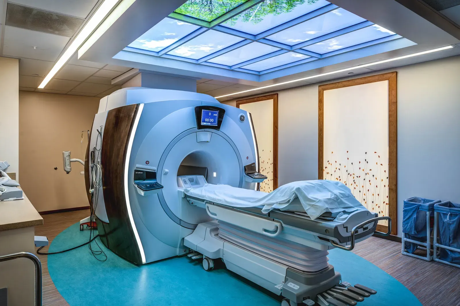 MRI suite with a skylight-style ceiling panel and a teal floor inlay around the scanner