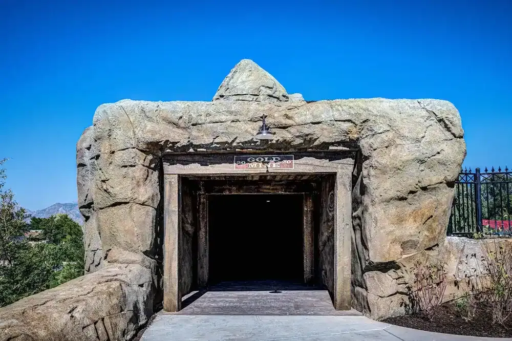 Rock-faced tunnel entrance with a timber frame and a sign reading Gold