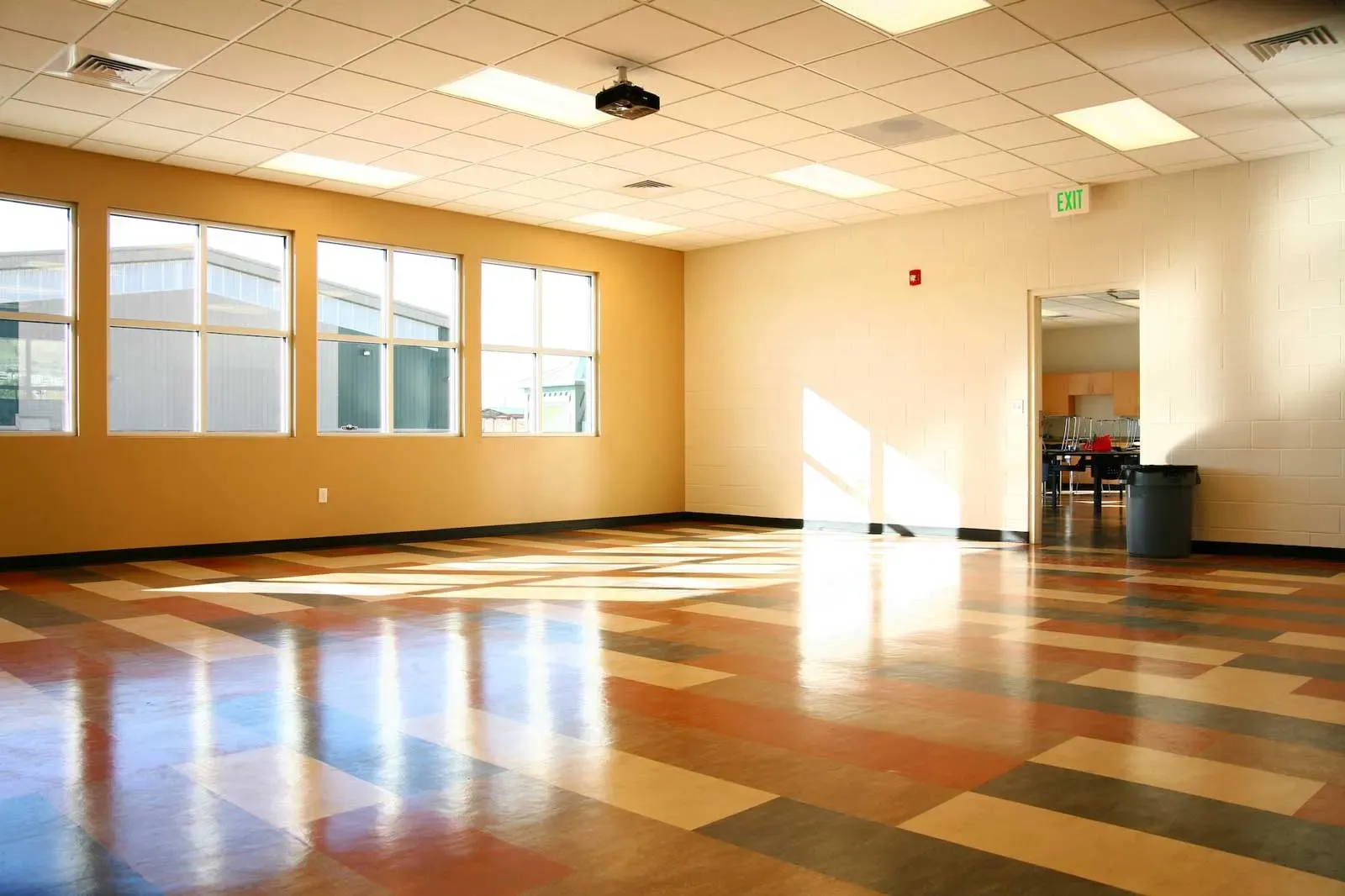 Empty room with tall windows and a patterned polished floor.