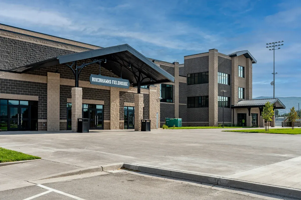 Fieldhouse entrance with a timber canopy and brick and block walls