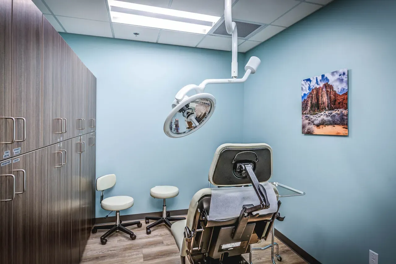 Procedure room with an exam light and a reclining exam chair.