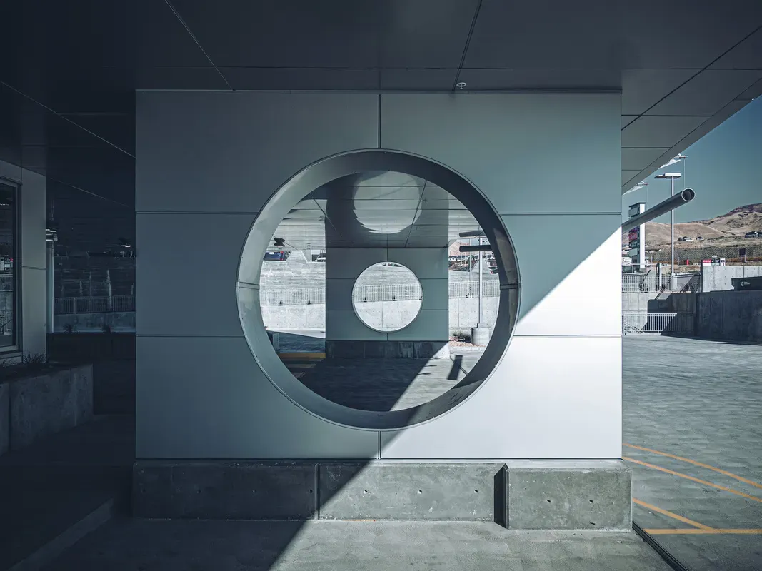 Round cutout in a metal panel wall at the base of the building