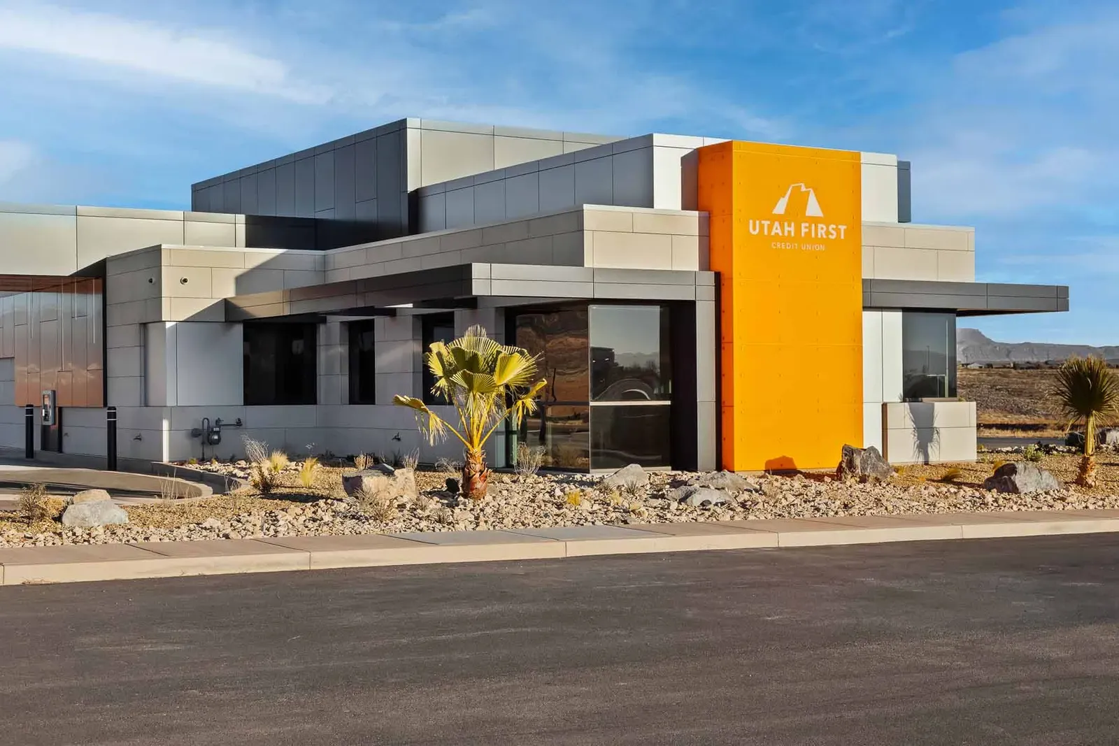 Front of the branch with an orange sign tower, gray panel walls, and desert landscaping.