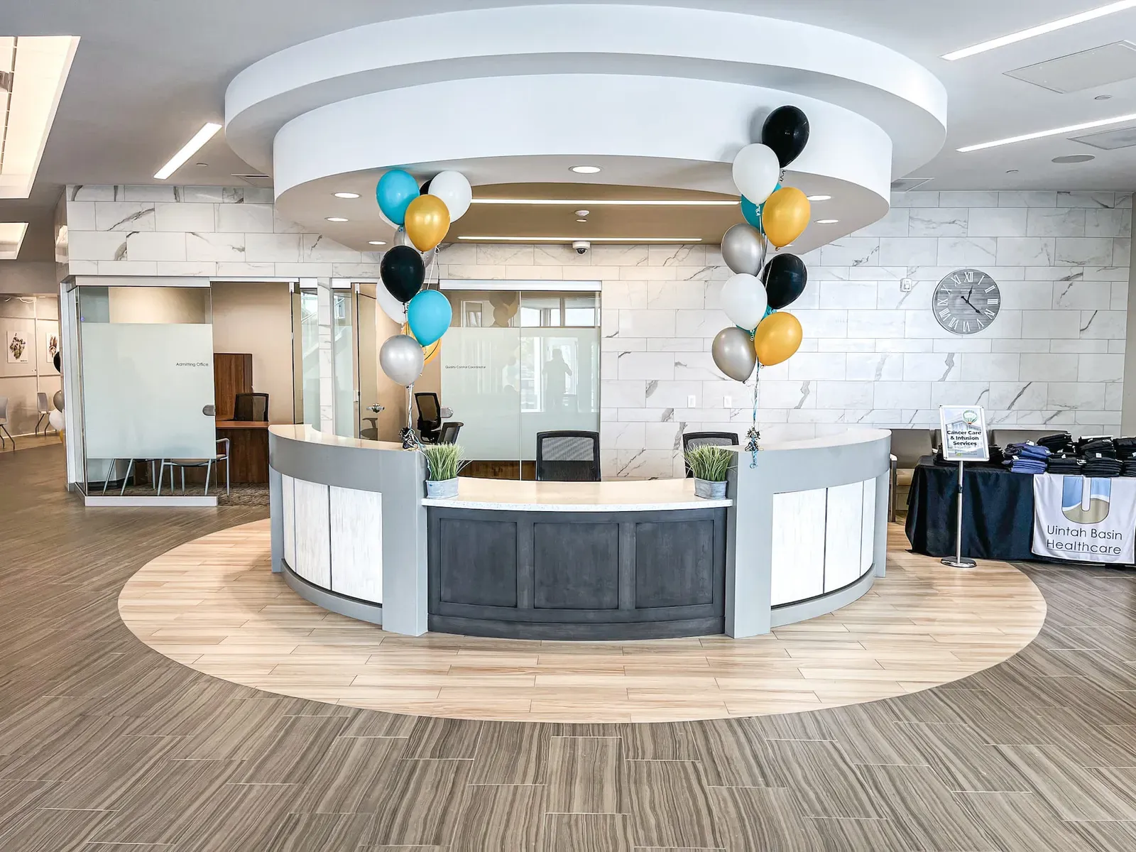 Round reception desk under a circular ceiling soffit, with balloons and a Uintah Basin Healthcare banner