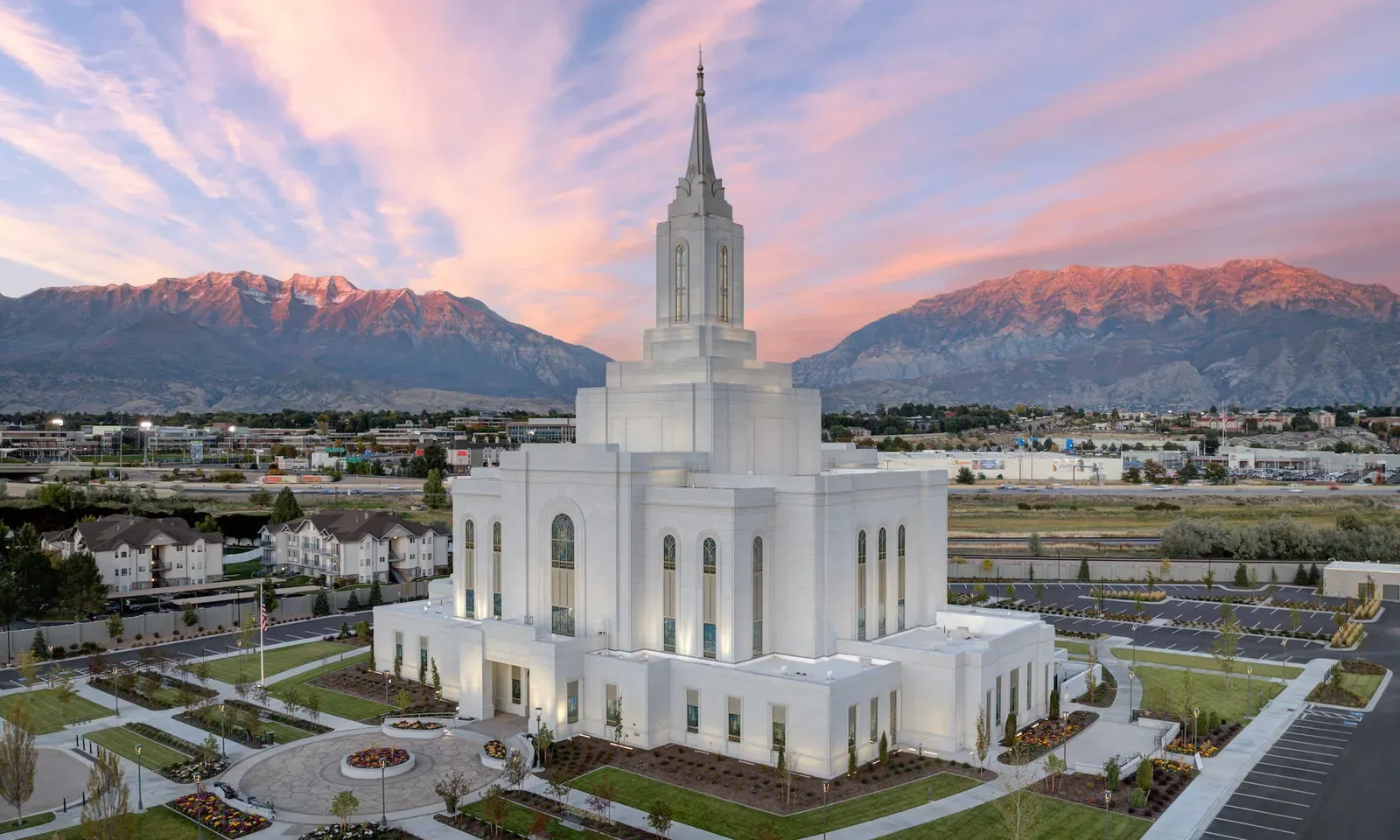 Aerial view of the temple at dusk with its grounds, nearby streets, and mountains behind.