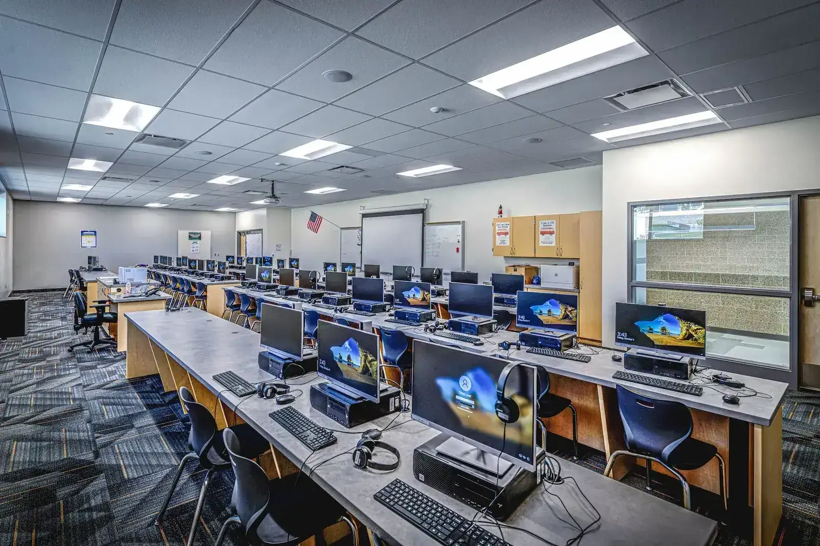 Computer lab with rows of desktop computers and headsets.