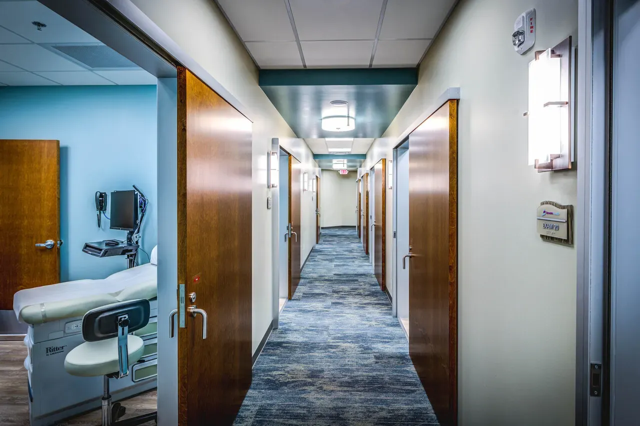 Hallway lined with wood doors leading to exam rooms.