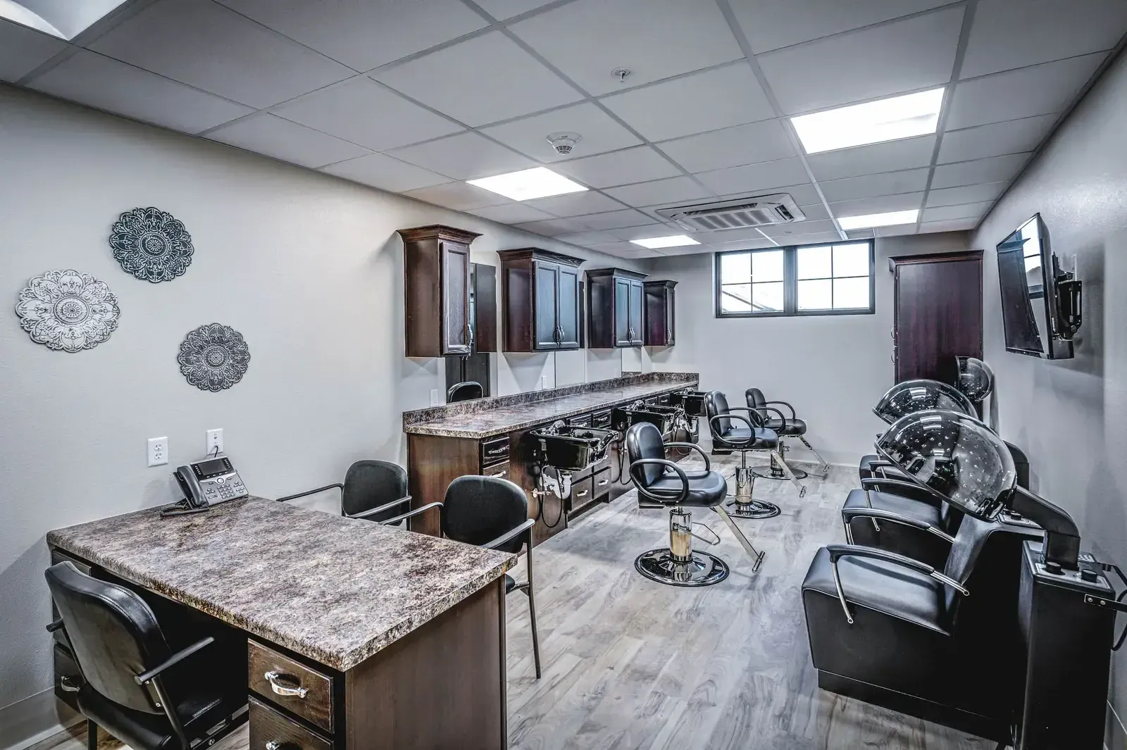 Salon with styling chairs, shampoo stations and a wood counter.