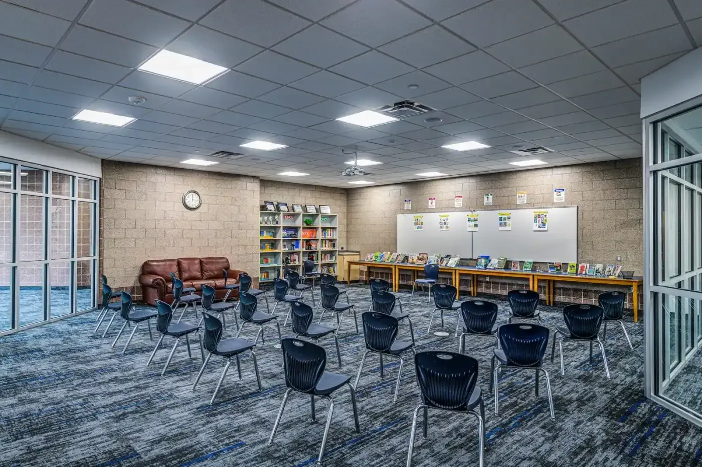 Group room with chairs set out in rows, bookshelves and a whiteboard.