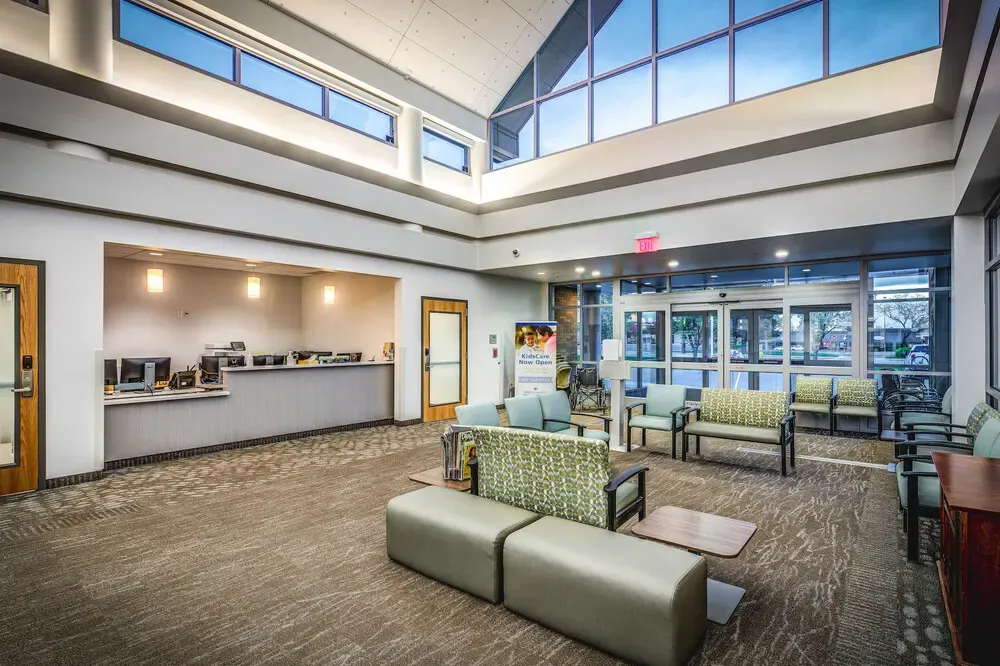 Lobby with seating and a check-in desk below a tall window wall.