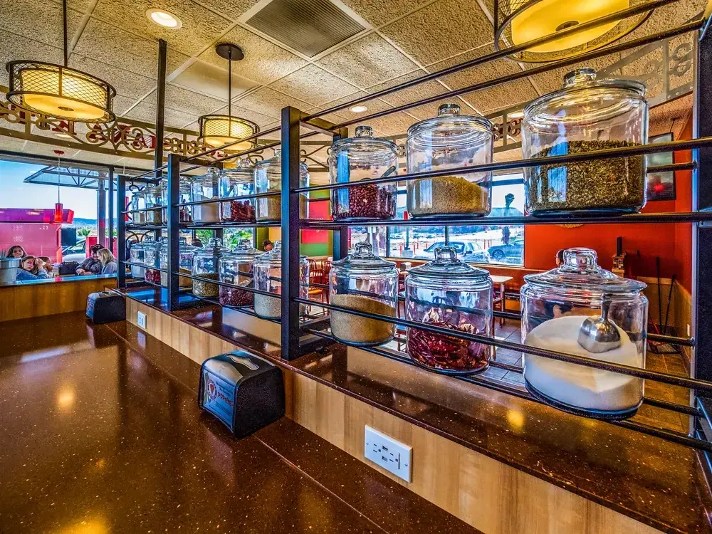 Shelves of glass condiment jars along the counter.