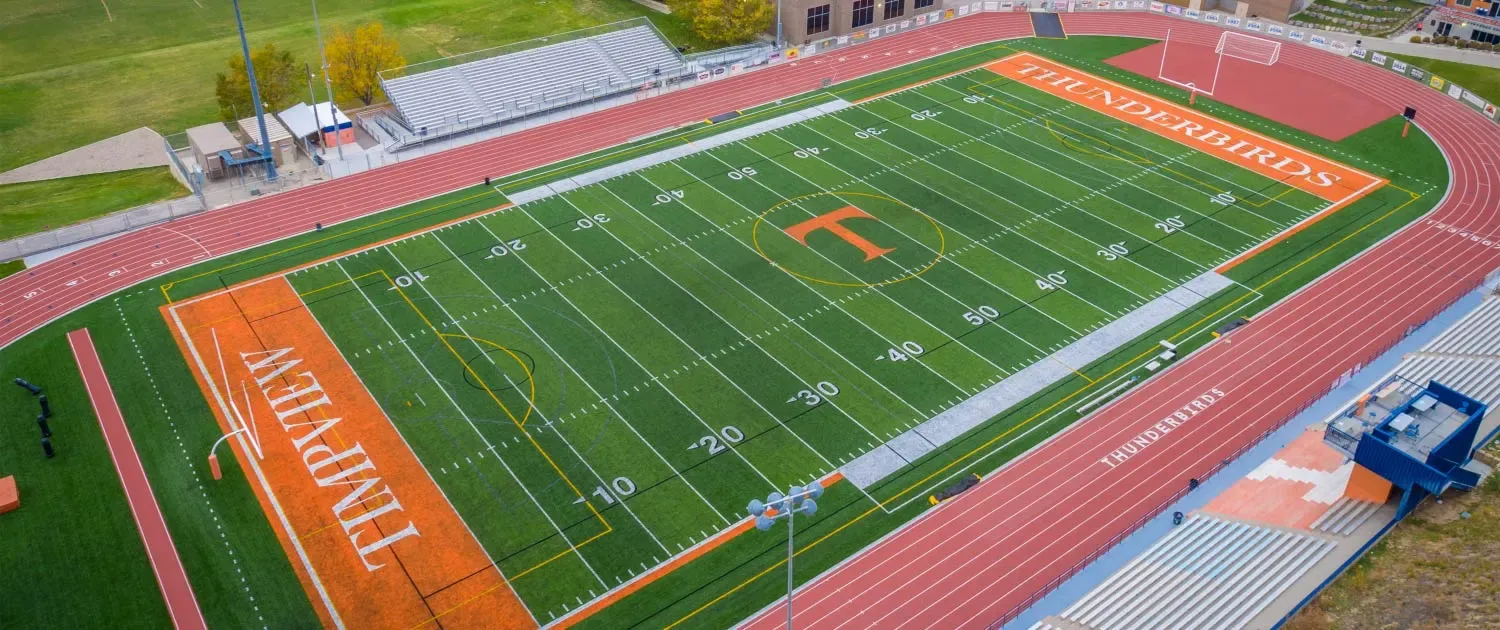 Aerial view of the Timpview football field with orange end zones, a running track and a grandstand.