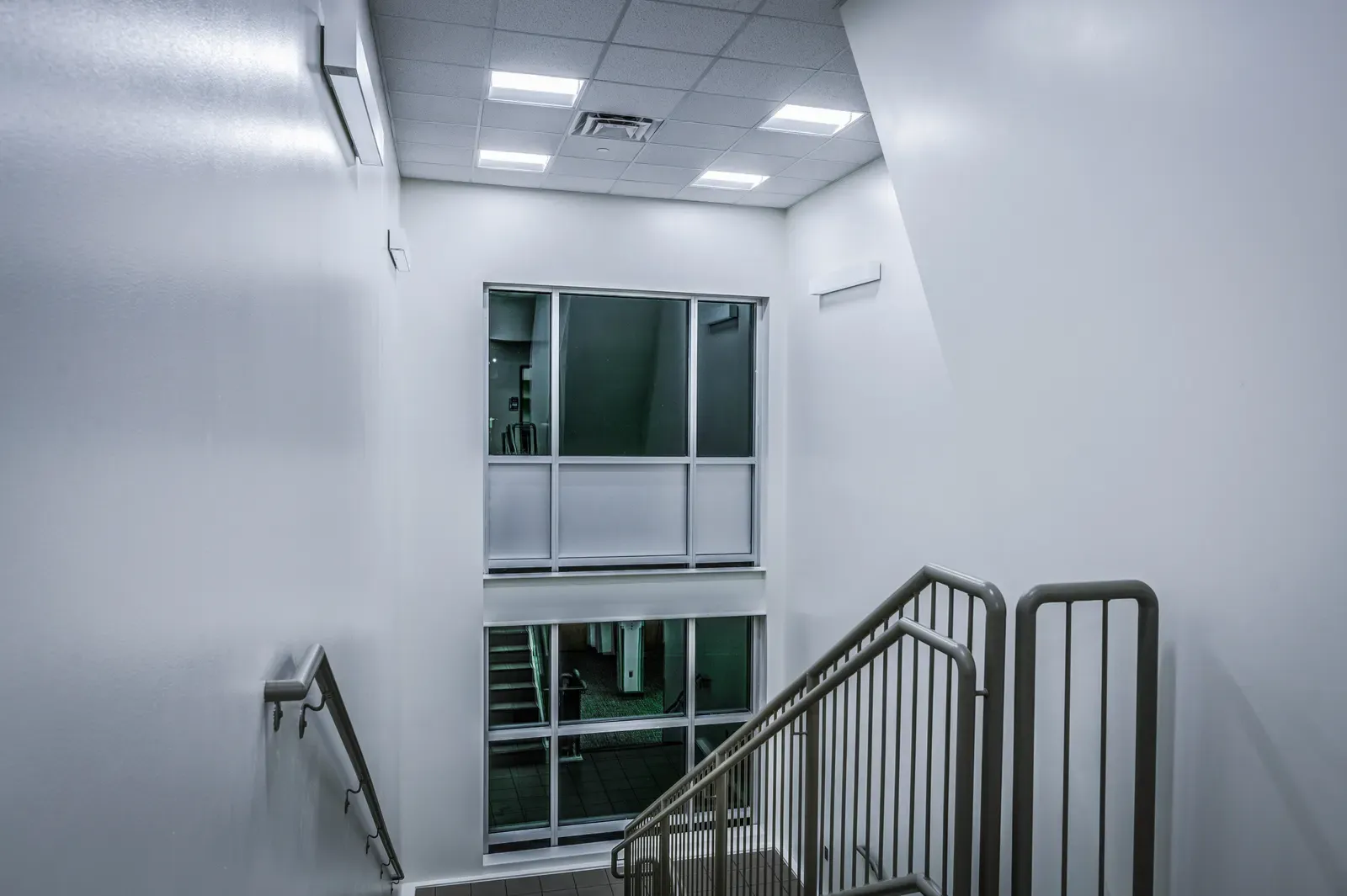 Stairwell with metal railings and a tall interior window