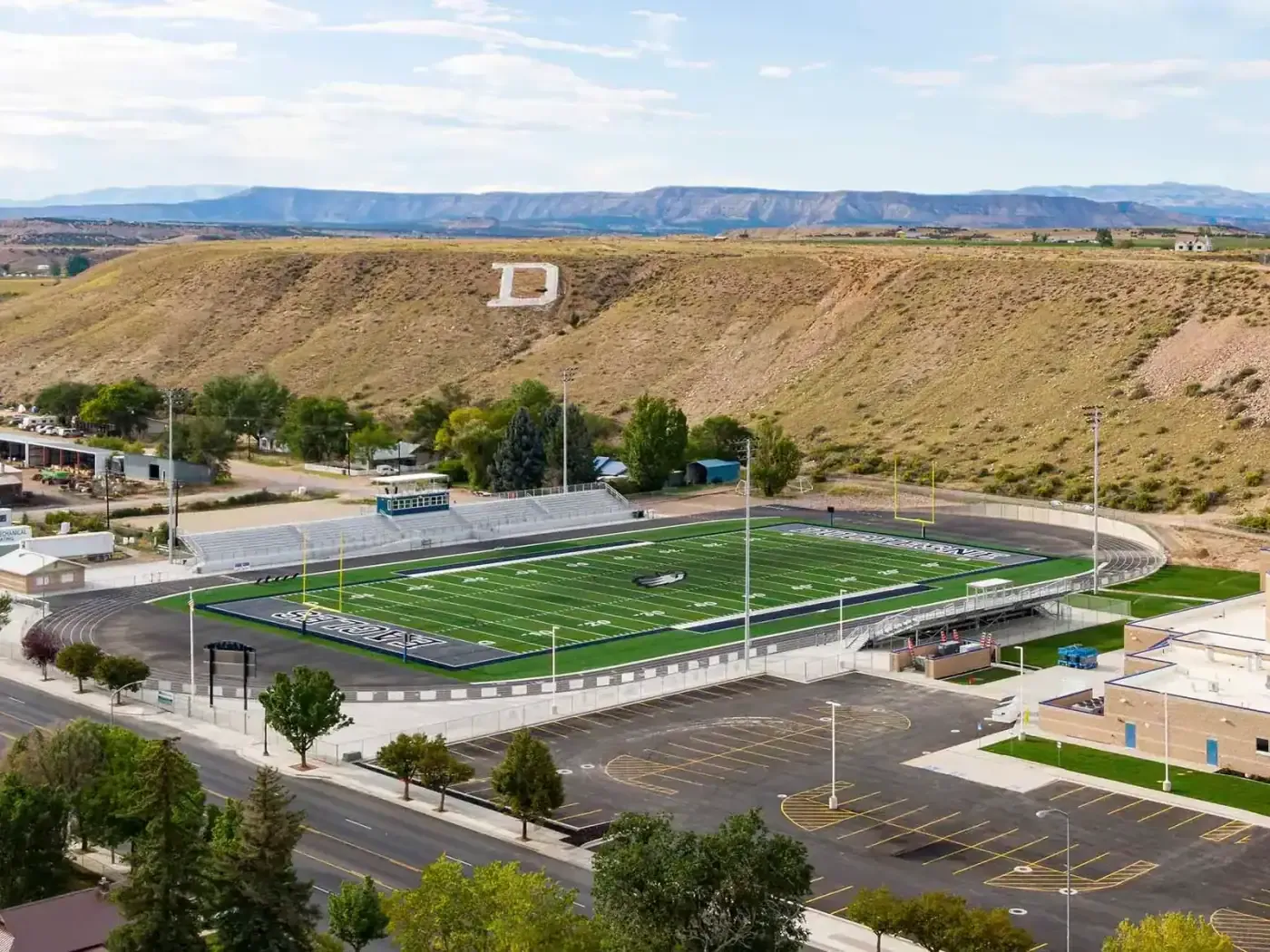 Aerial view of the football field and track with a large "D" on the hillside behind
