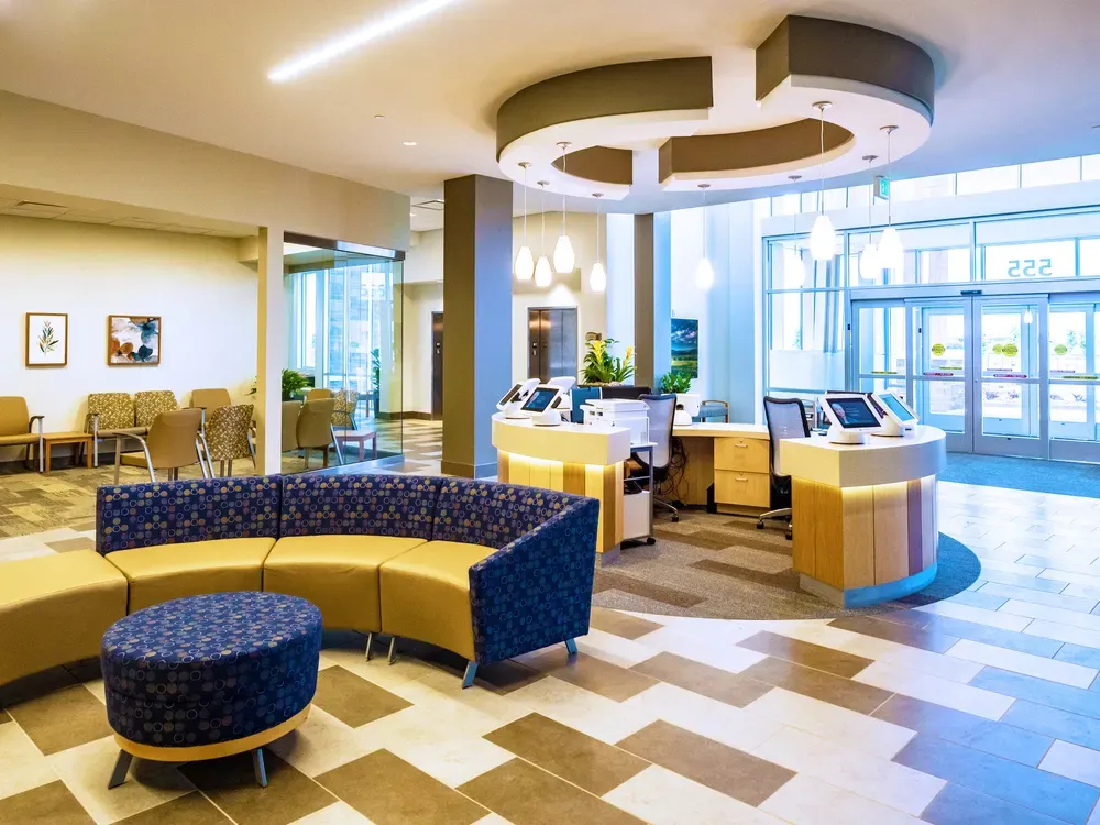 Lobby with a curved sofa, reception counters and glass entry doors.