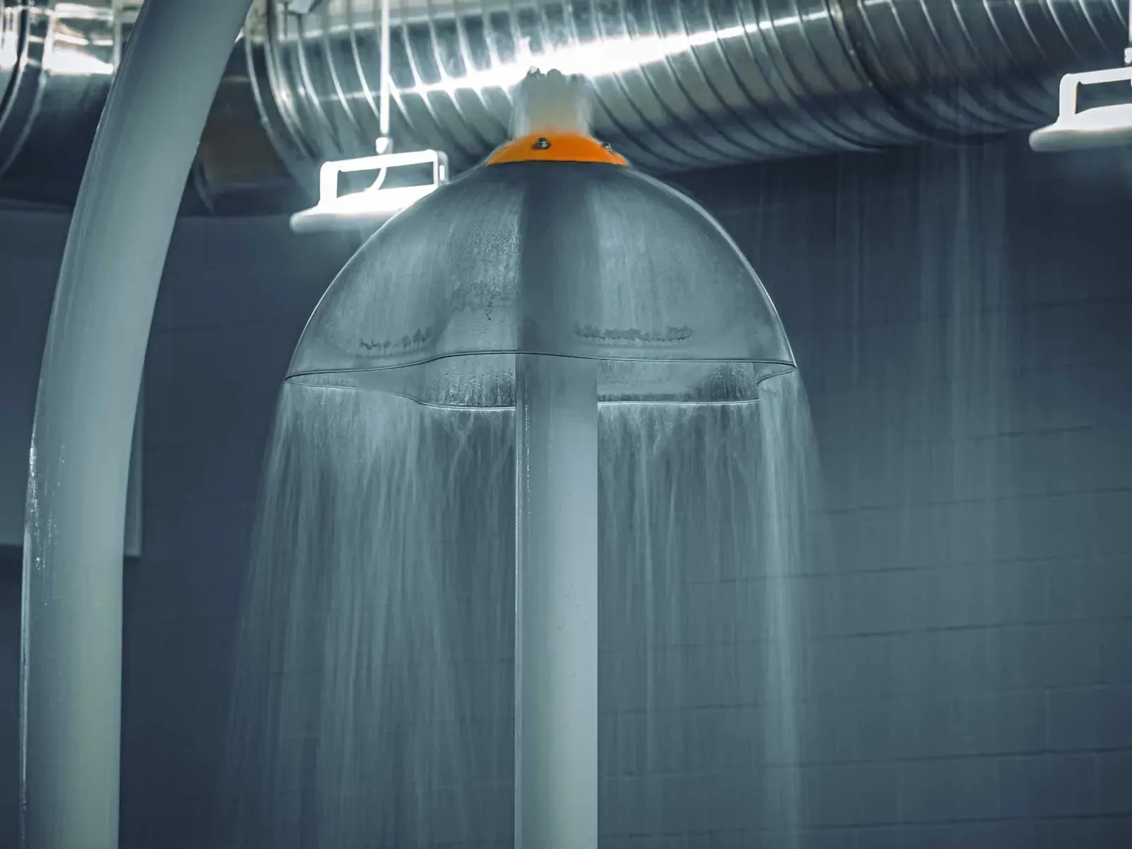 Close view of a water curtain falling from an umbrella-shaped spray feature.