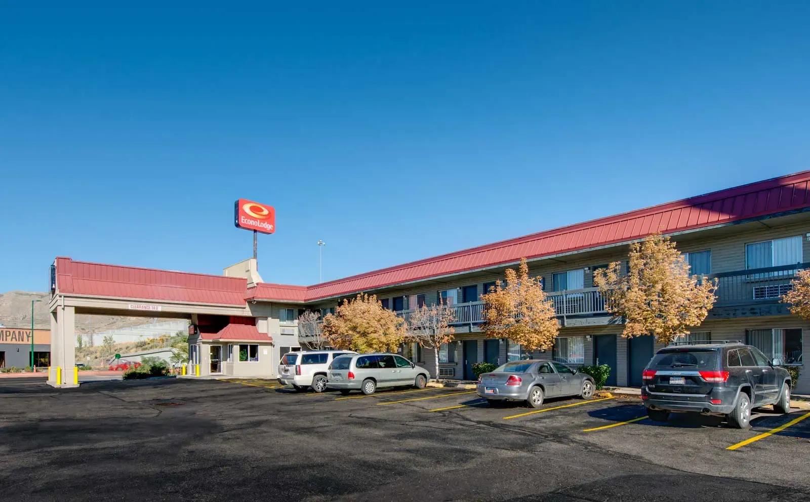 Two-story motel with a red roof, a covered entrance and an Econo Lodge sign, with cars parked in front
