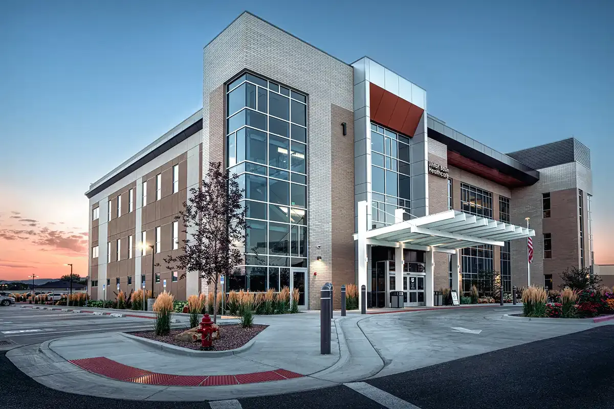 Three-story brick and glass building with a white entry canopy